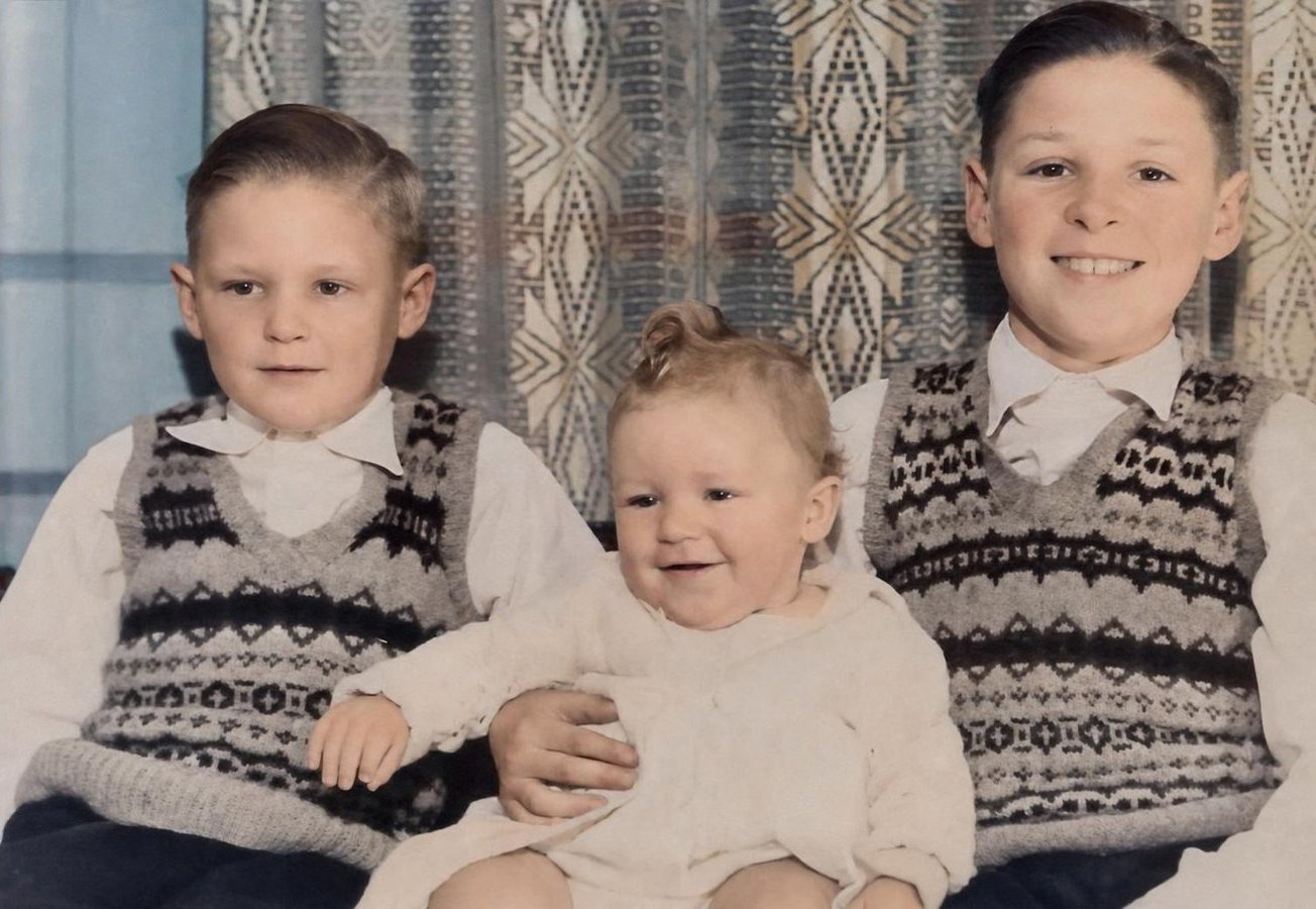 The same photo restored: three brothers in colour, damage repaired